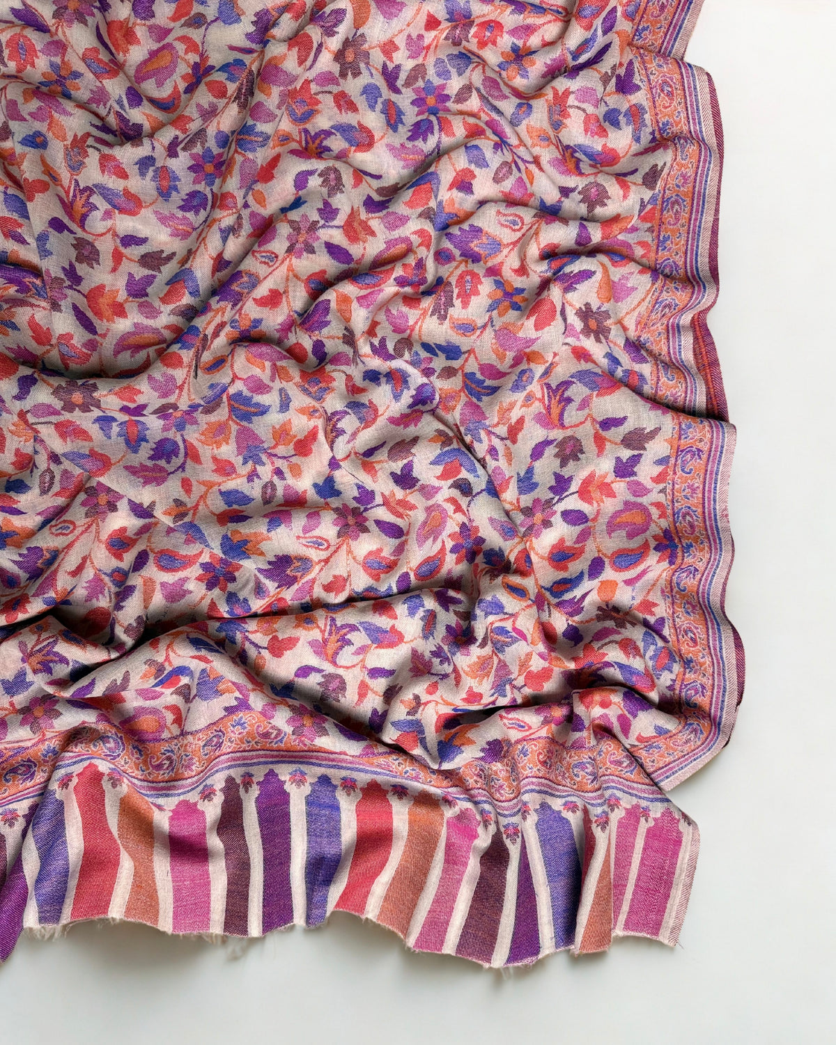 Blush multicolour Kani pashmina shawl gathered in soft folds, showing the drape and floral weave