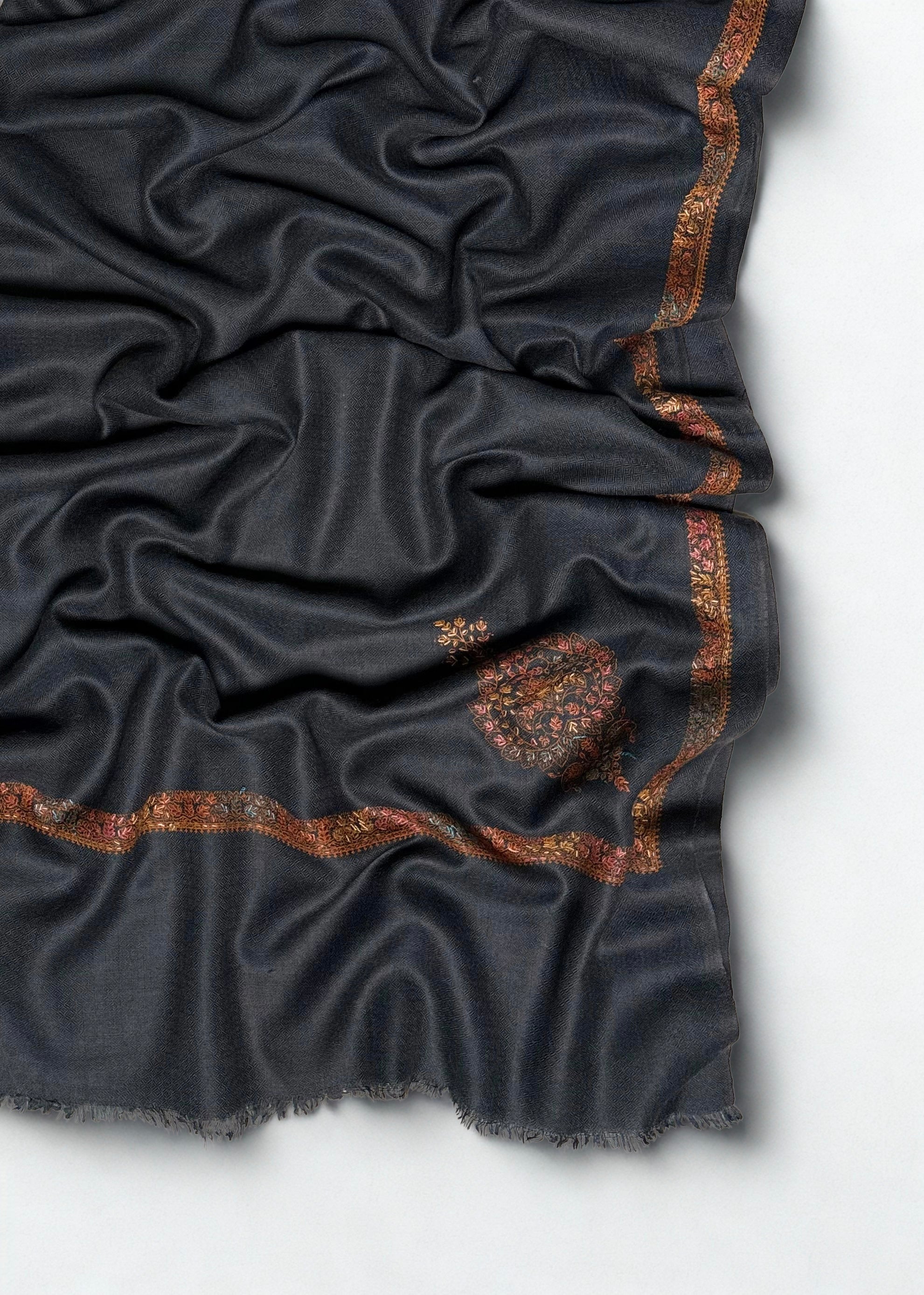Folded charcoal grey Swati Shahtoosh shawl showing the full length, fine embroidered edge and single paisley buta