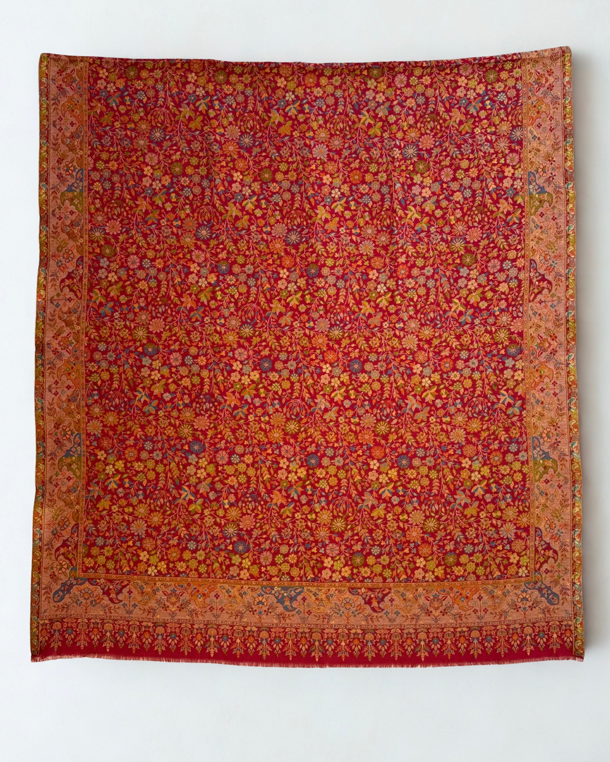 Crimson Zari Kani pashmina shawl folded to show the corner border and the fringed end