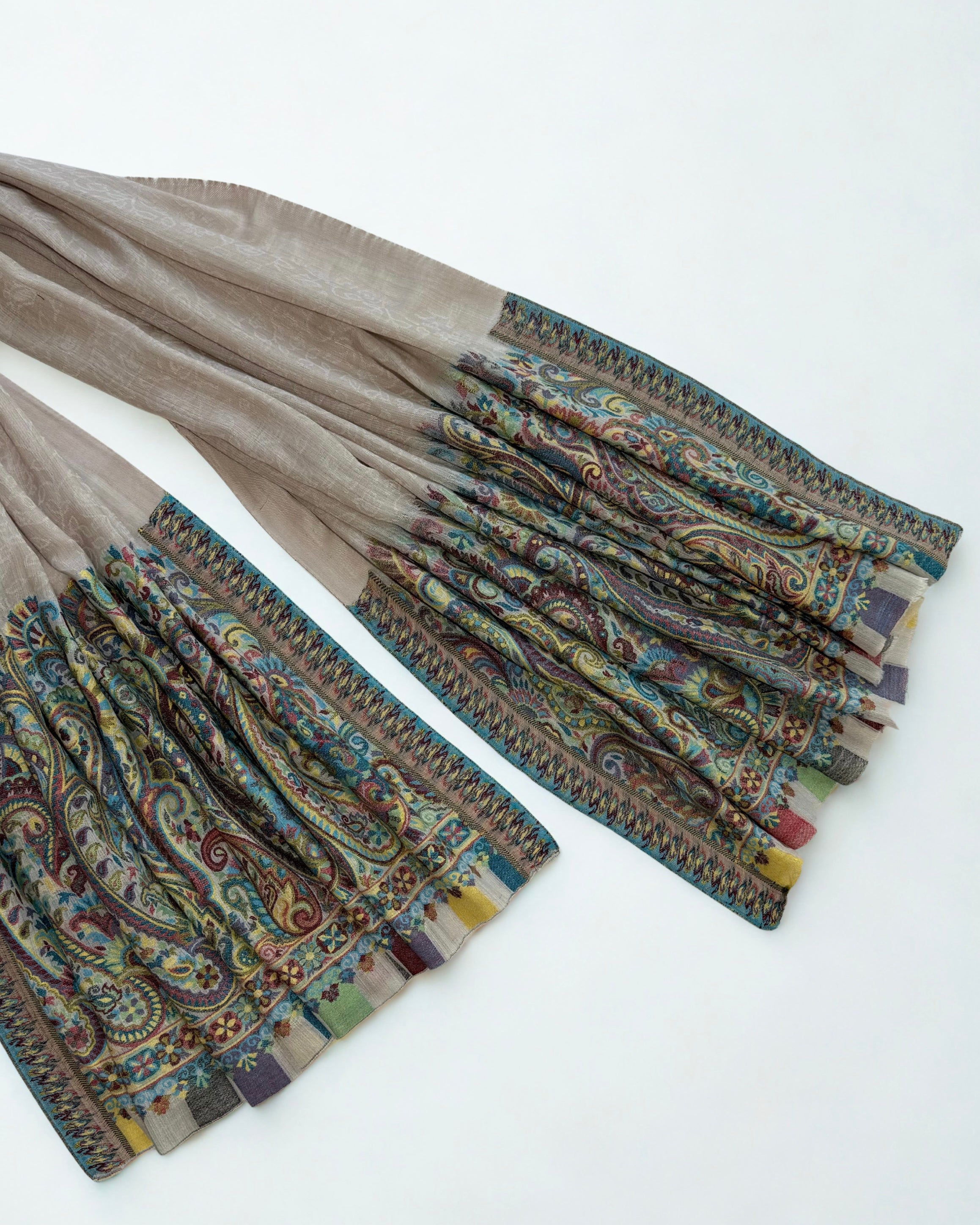 Shawl folded to show the join between the grey ground and the turquoise border