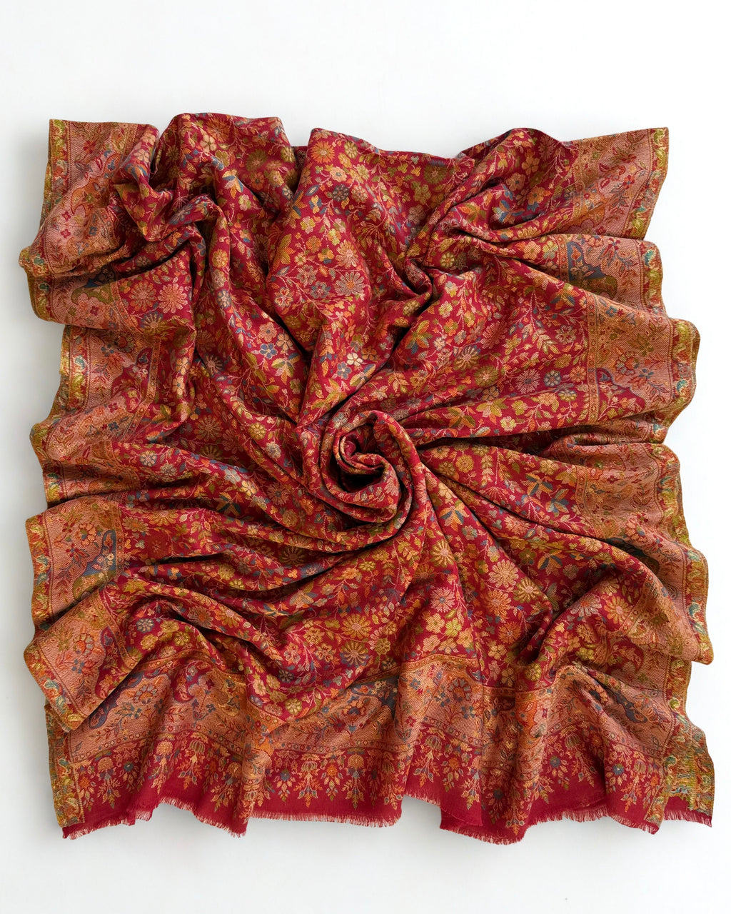 Close view of the gold zari thread woven through the crimson floral Kani field