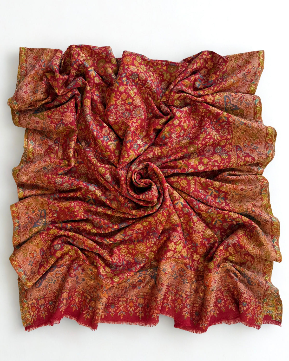 Close view of the gold zari thread woven through the crimson floral Kani field