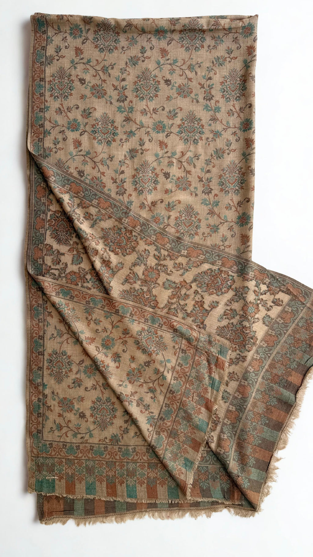 Camel Kani pashmina shawl laid flat, all-over verdigris and rust flowering vines with a scrolling border and striped fringed end