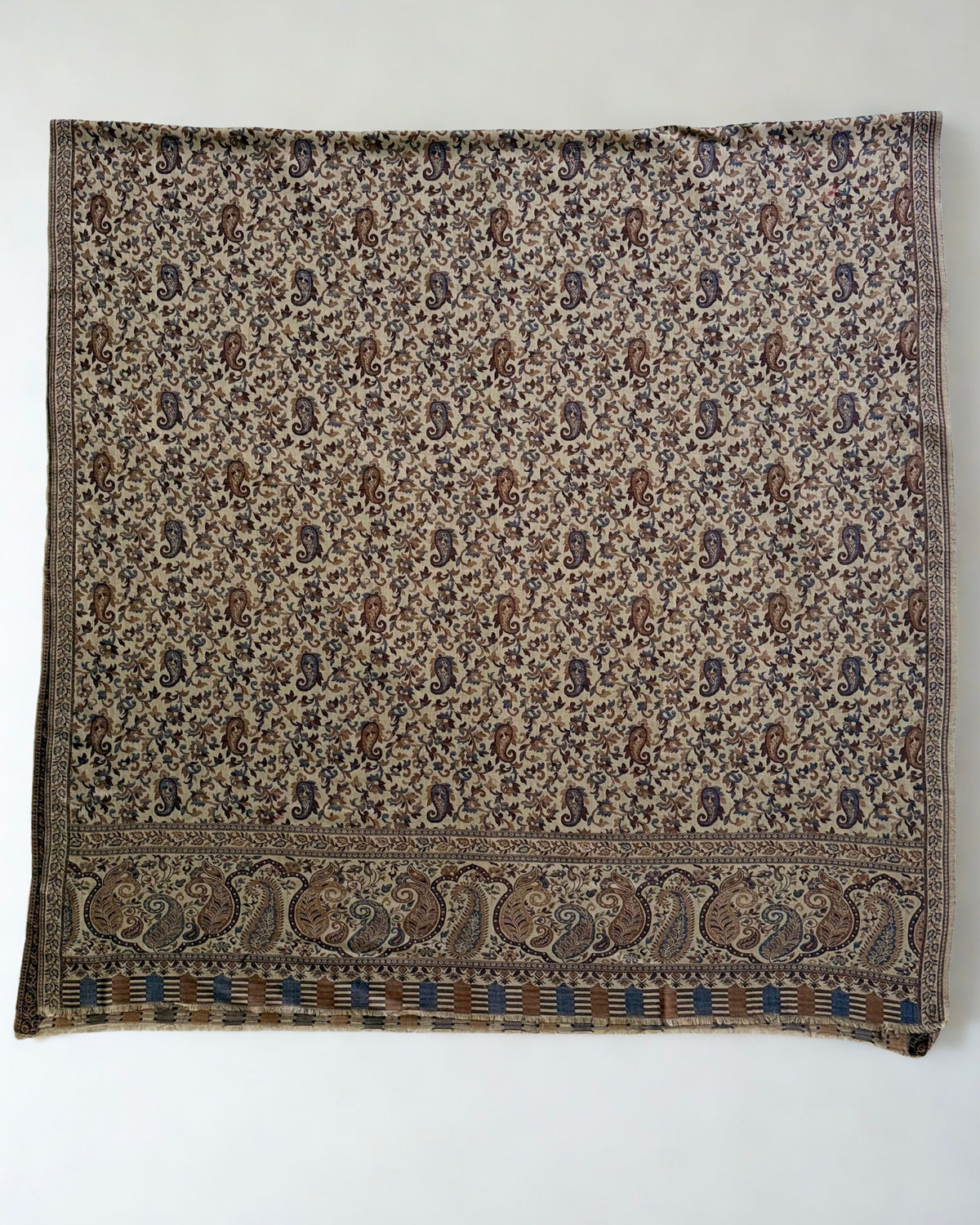 Sand Kani pashmina shawl gathered in a soft swirl, showing the all-over paisley weave and border