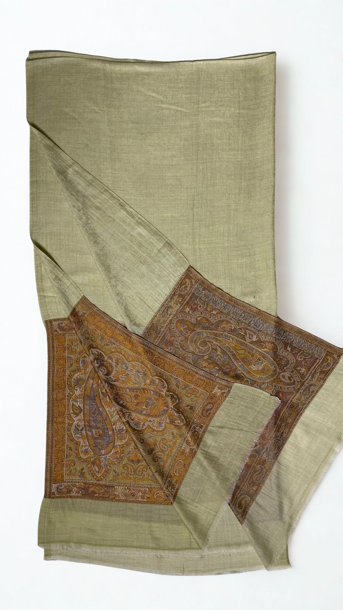 Pistachio Palladar shawl folded with one end turned back, showing both bronze paisley pallas against the pale green field