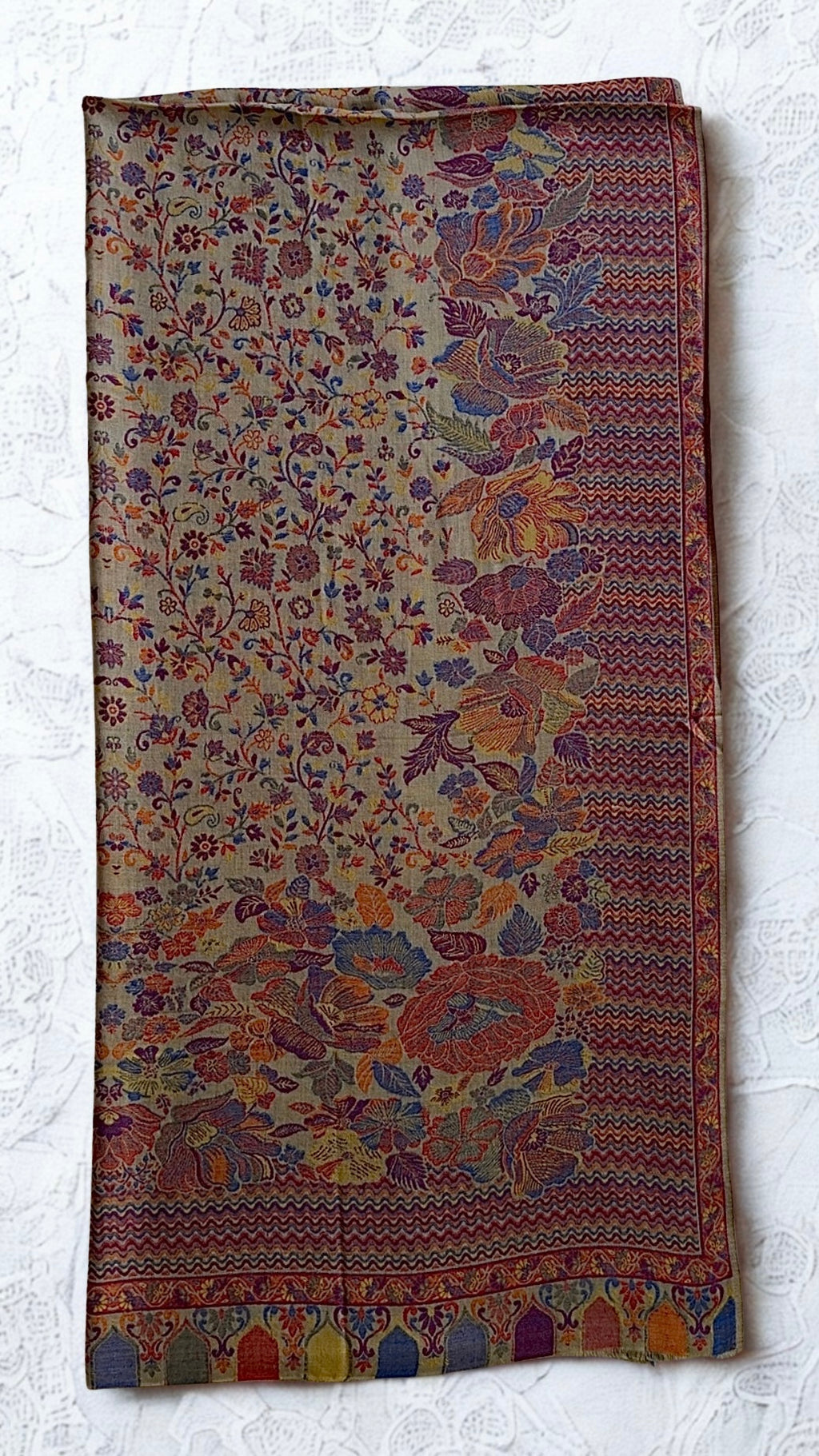 Antique rose Kani pashmina shawl folded lengthwise, showing the graduated floral field and coloured arched niches at the end