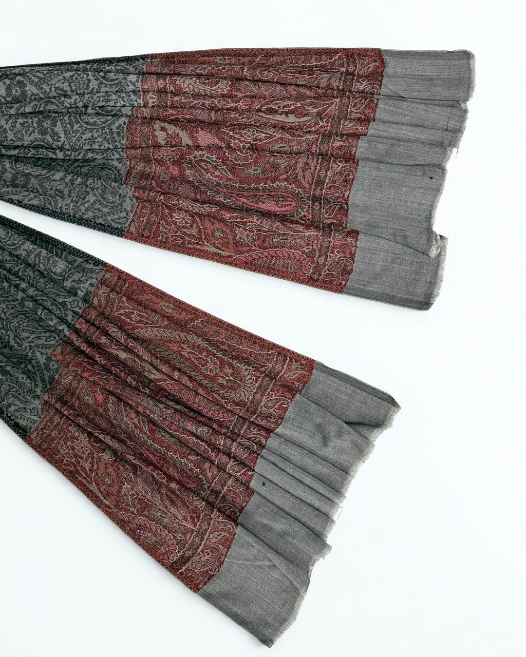 Detail where the self-patterned charcoal field meets the antique rose band