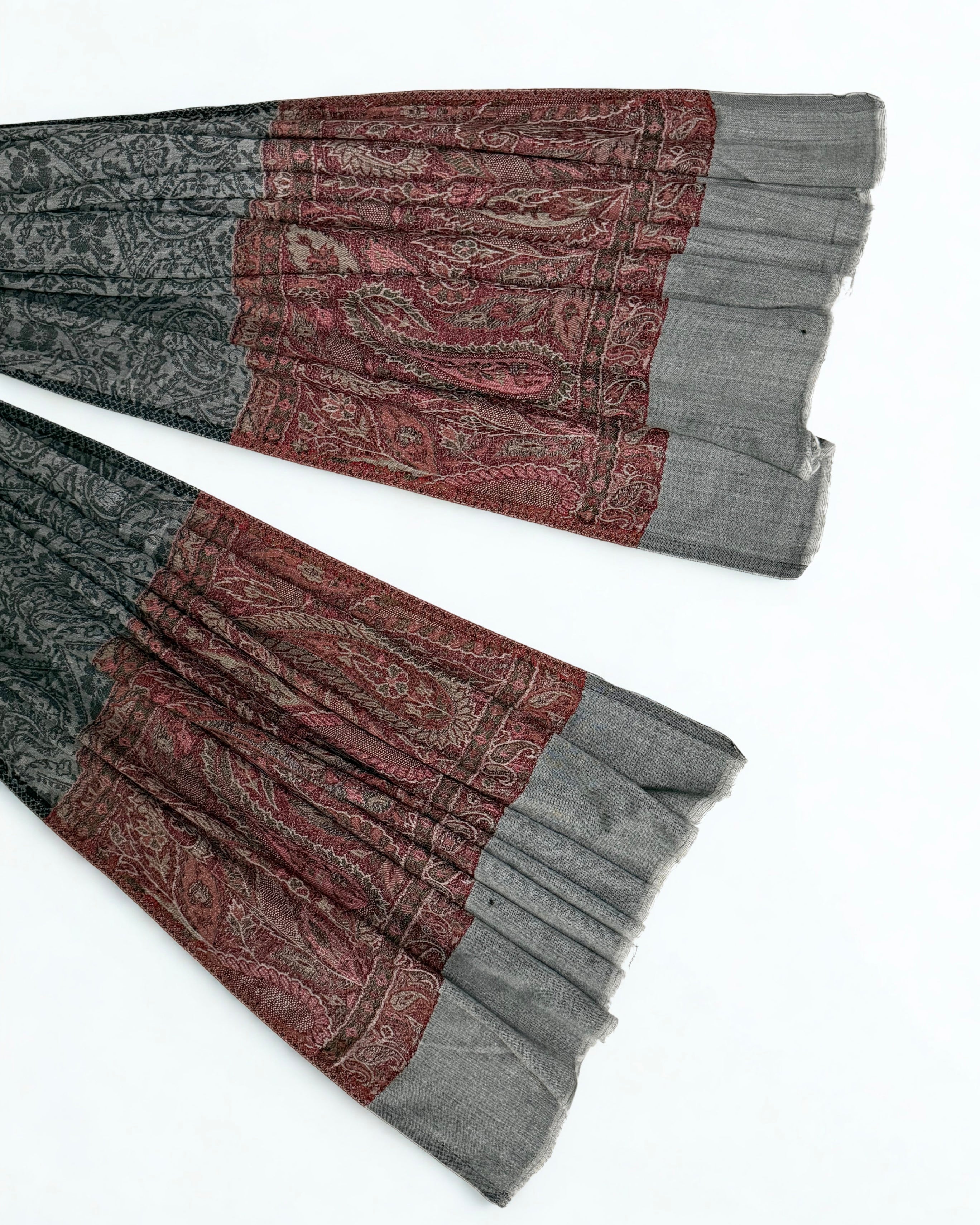 Detail where the self-patterned charcoal field meets the antique rose band