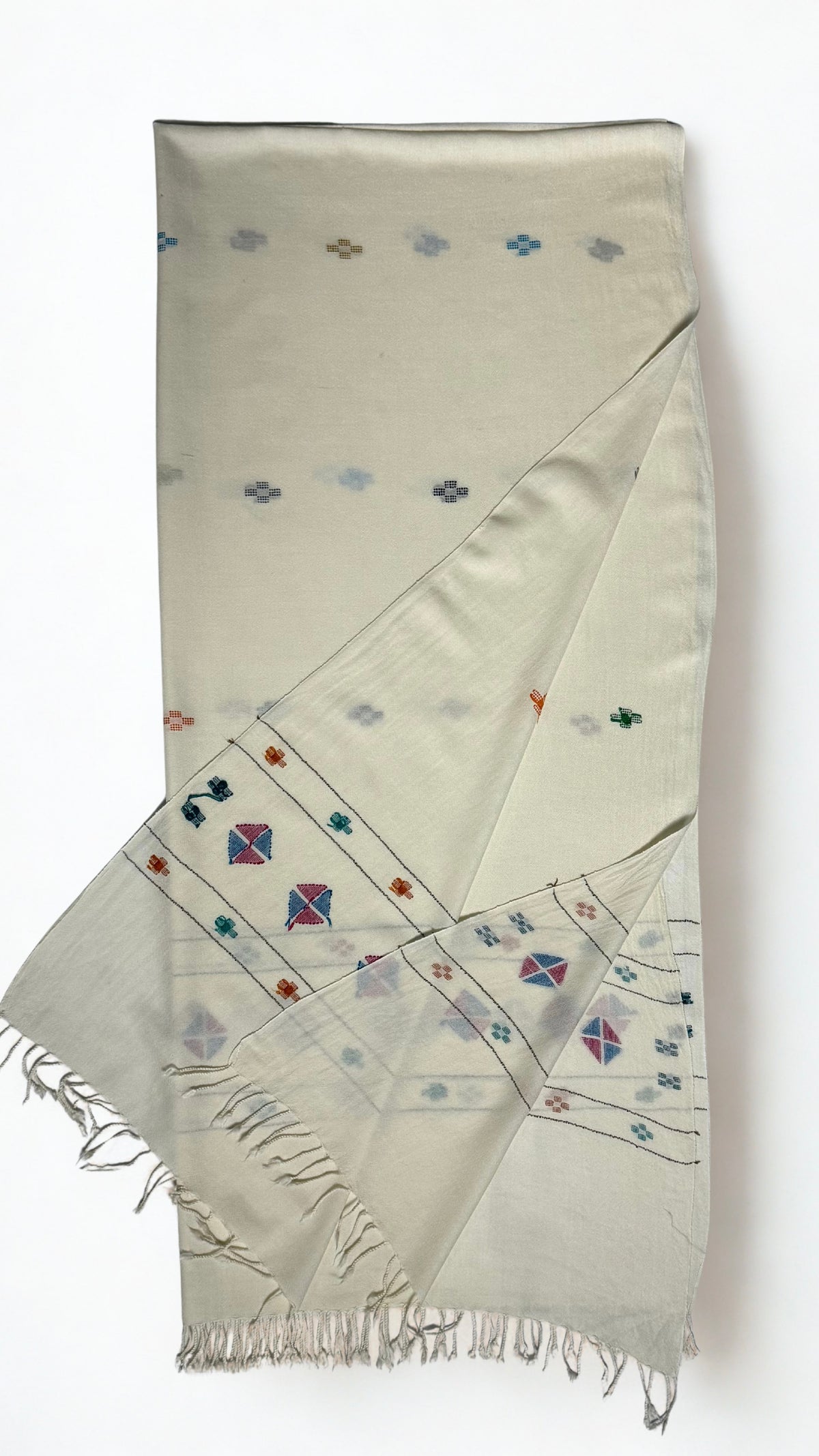 Off-white Khadi Swati Shahtoosh shawl folded lengthwise, showing the woven multicoloured buti and the diamond medallion border at the fringed end