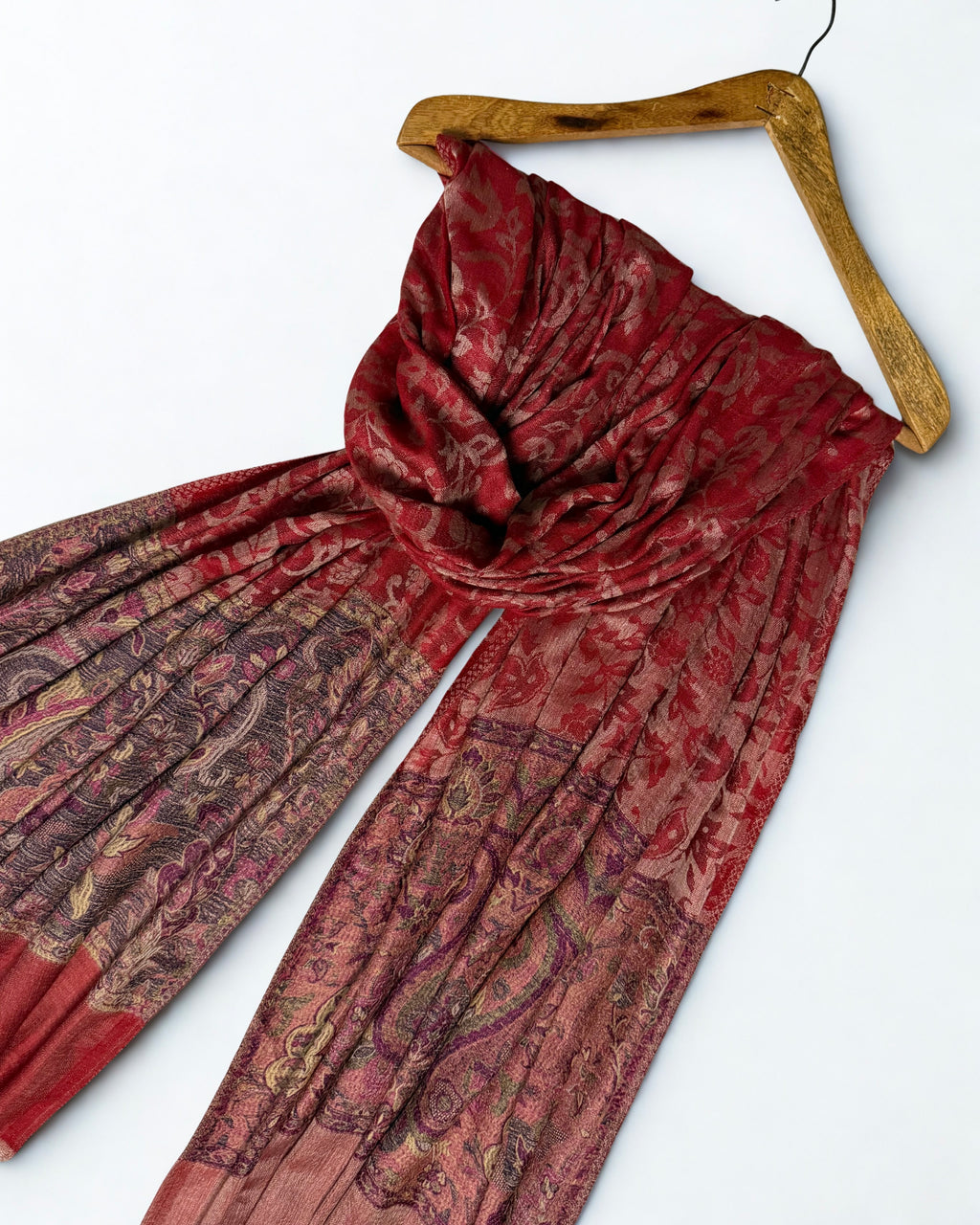 Close view of the large paisleys worked in gold, rose and aubergine on a dark indigo ground
