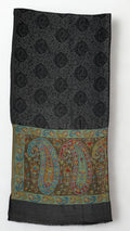 Dark charcoal pashmina ring shawl folded, showing the black paisley medallion lattice and a palla of large teal, crimson and saffron paisleys