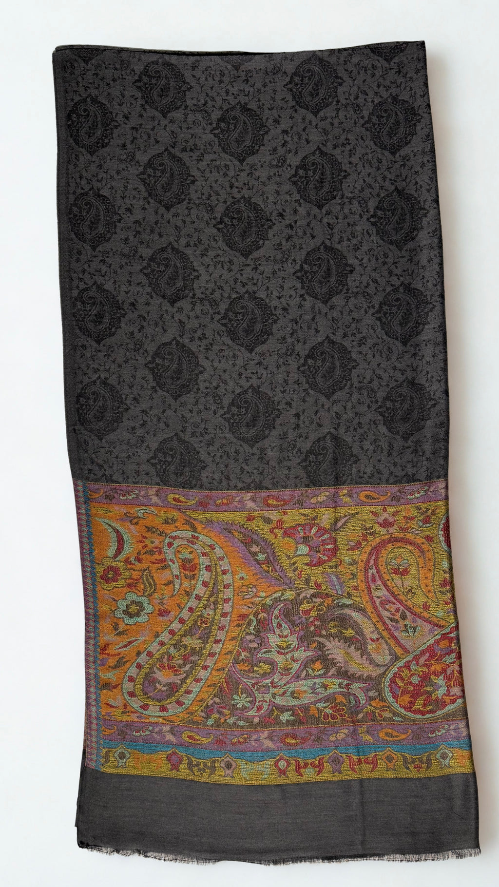 Dark charcoal pashmina ring shawl folded, showing the black paisley medallion lattice and a saffron and crimson paisley palla