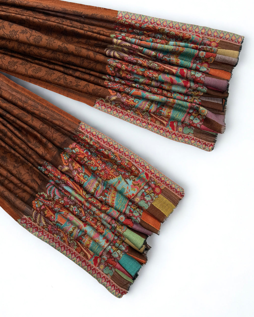Rust pashmina shawl swirled to show its drape above the landscape border