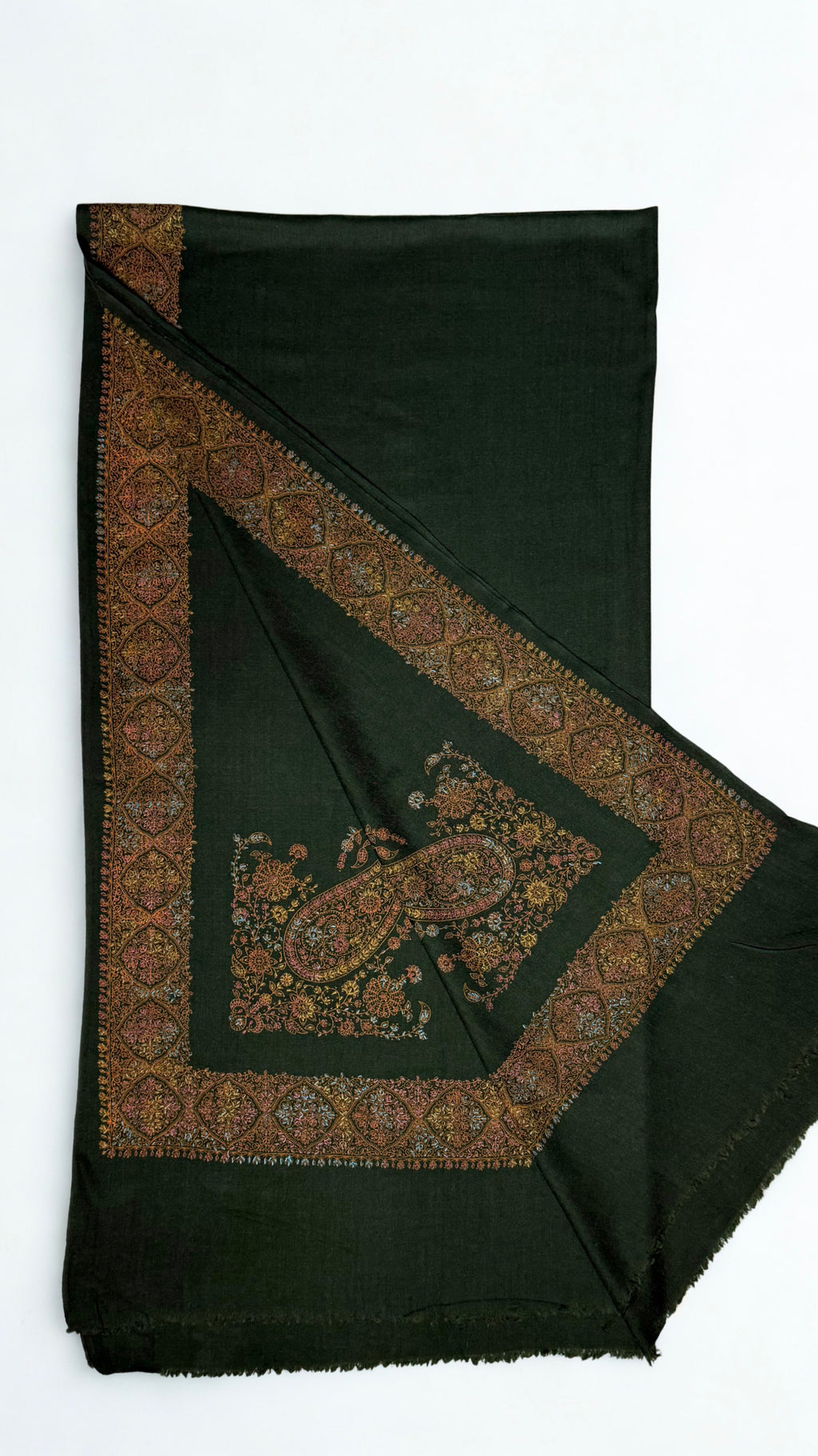 Forest green Swati Shahtoosh shawl with one corner turned back, showing the wide hand-embroidered medallion border mitred at the corner around a large paisley motif