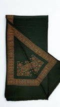 Forest green Swati Shahtoosh shawl with one corner turned back, showing the wide hand-embroidered medallion border mitred at the corner around a large paisley motif
