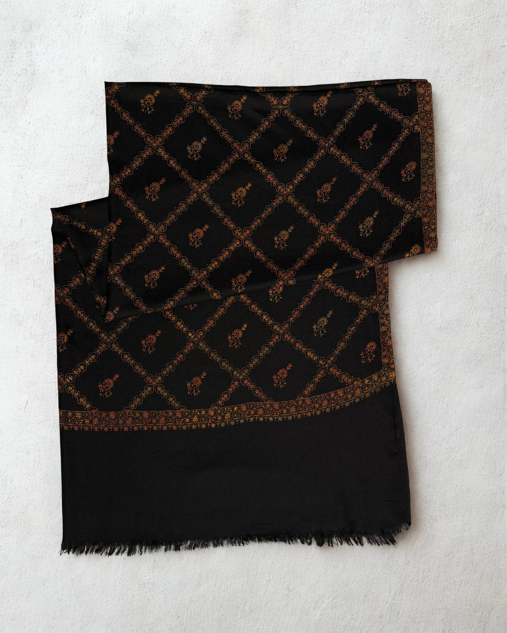 Black Swati Shahtoosh shawl folded flat, gold jaal lattice with flowering buti and a scrolling border