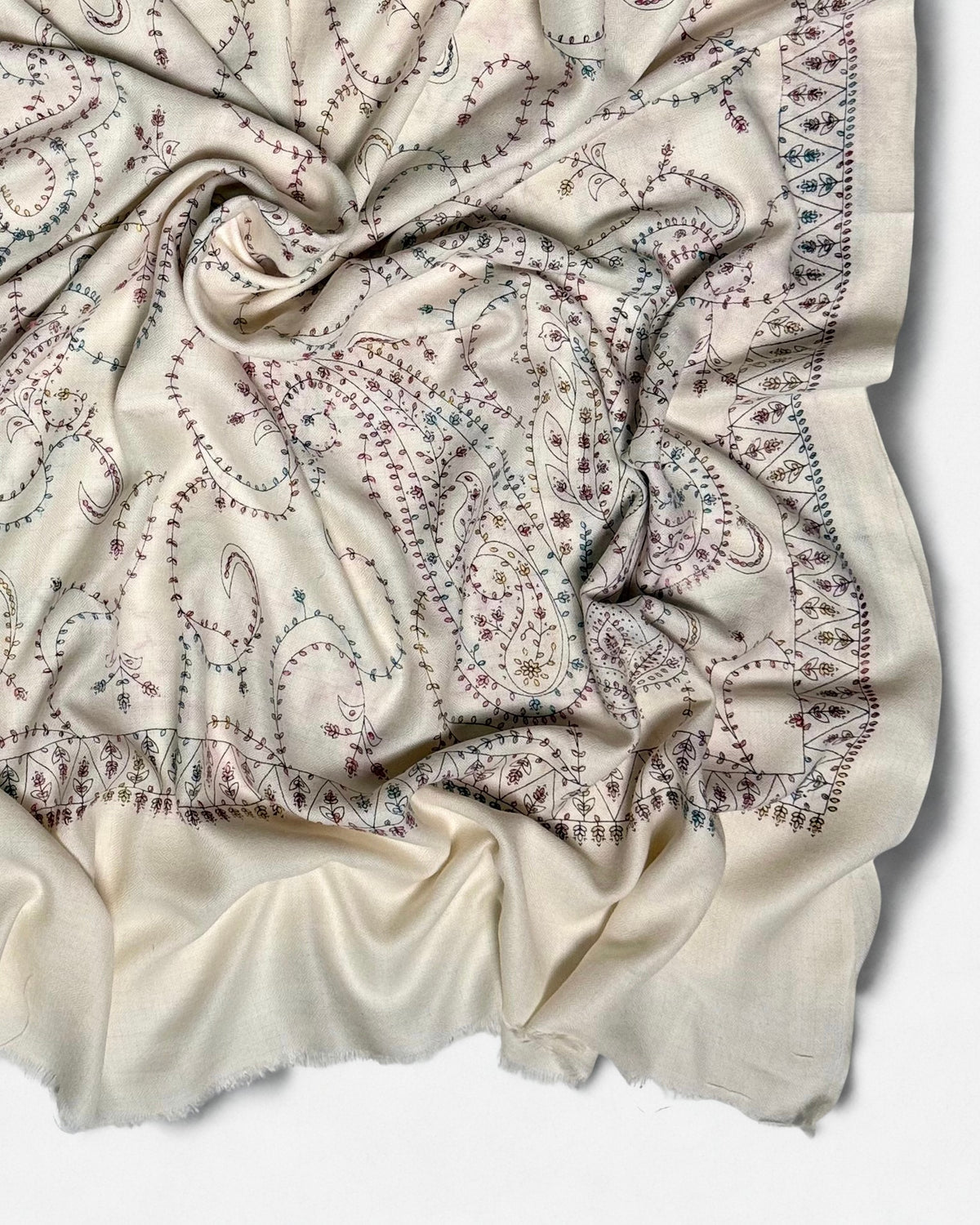 Paisley and vine embroidery covering the whole field of the white Swati Shahtoosh shawl