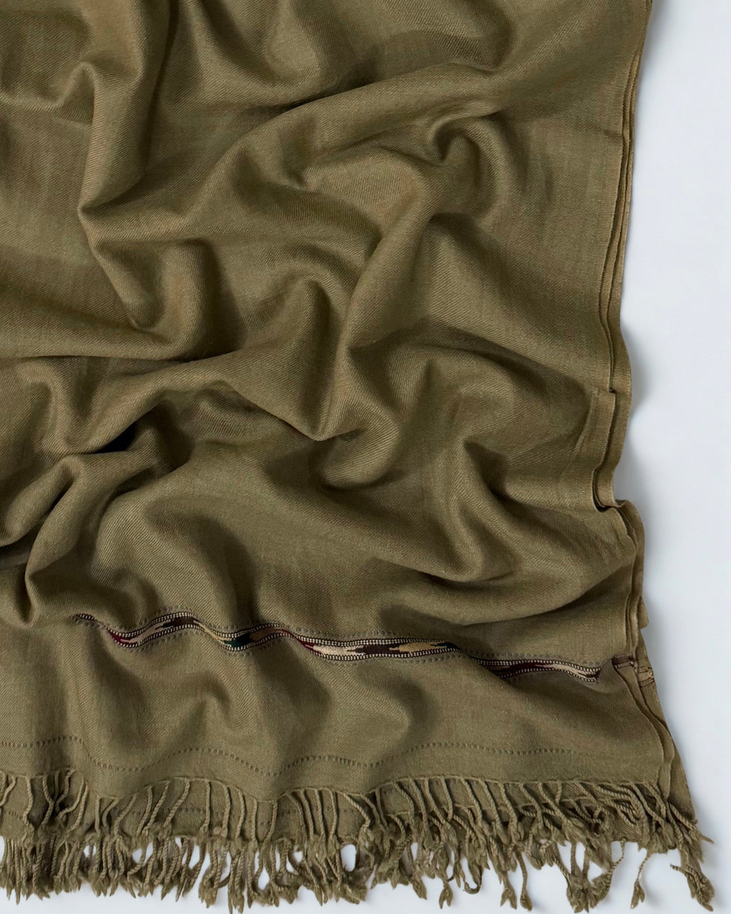 Close-up of the brown men's Swati pashmina shawl showing the multicoloured woven band and knotted fringe