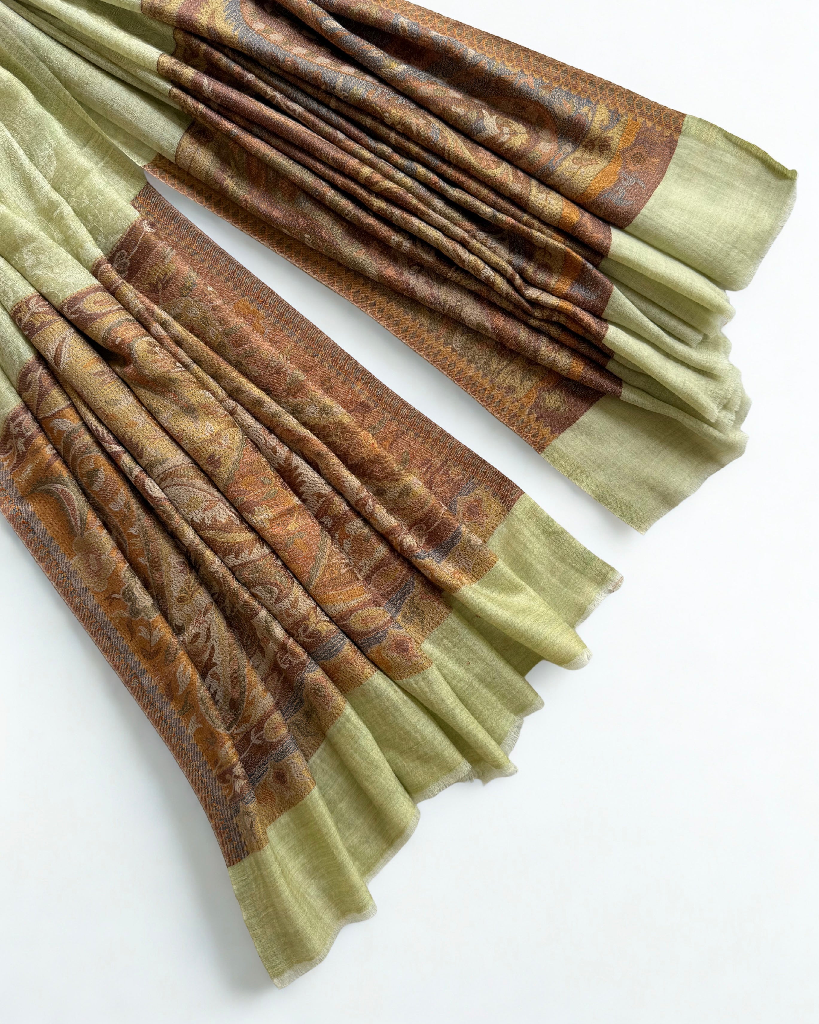Pistachio pashmina shawl swirled to show its drape above the amber border