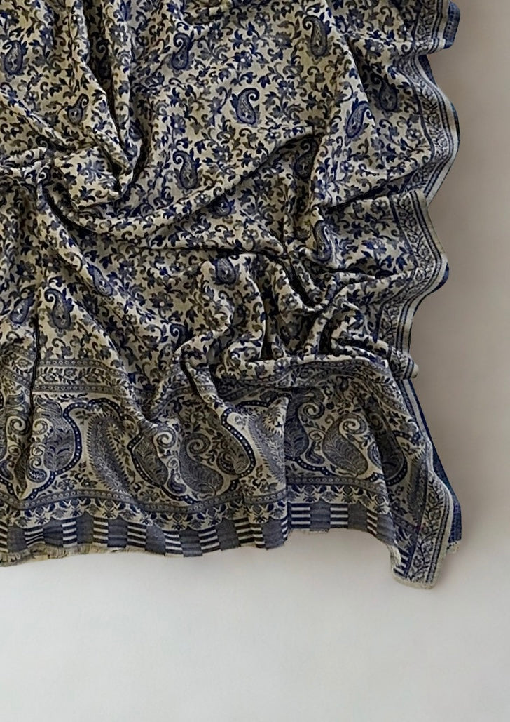 Stone and navy Kani pashmina shawl gathered in soft folds, showing the all-over paisley weave