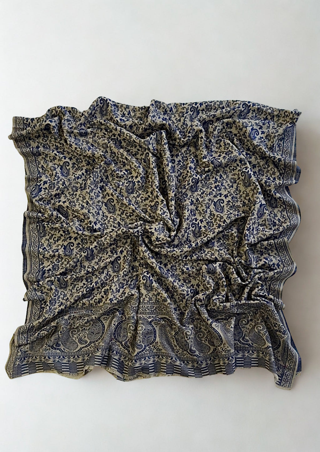 Close view of the fine navy Kani paisley weave and border detail on a stone pashmina ground