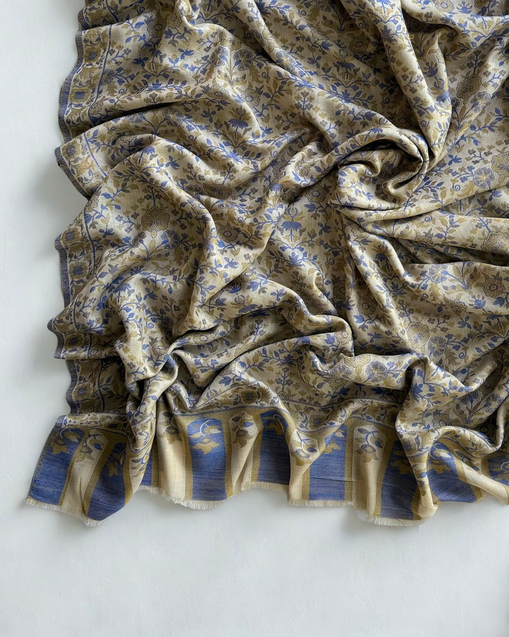 Ivory Kani pashmina shawl draped in soft folds, showing the cobalt floral weave and border