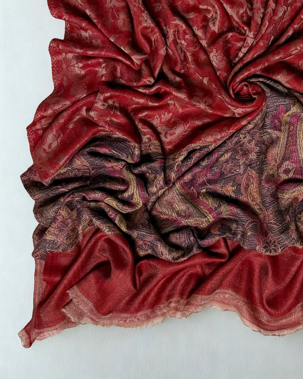 Folded scarlet Palladar shawl showing the join between the red ground and the indigo border
